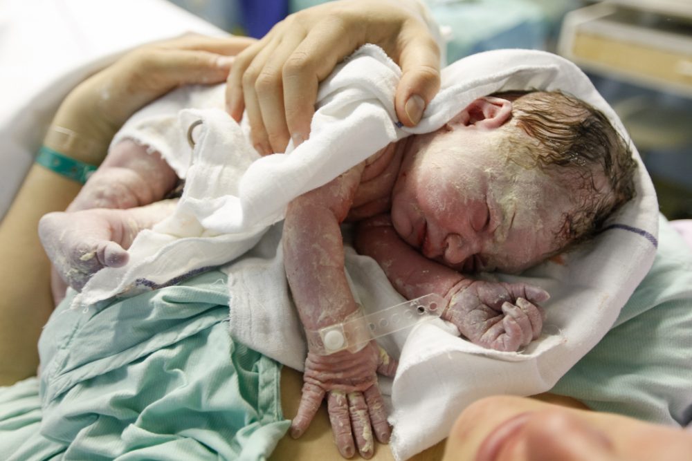 Why are newborn babies covered with a waxy white substance (vernix caseosa)