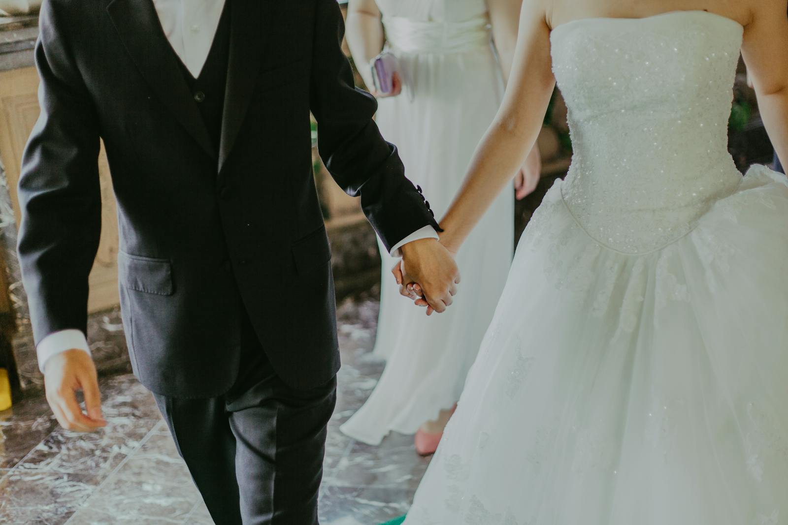 How to Plan a Wedding Within a Small Budget? 1 Woman Wearing White Wedding Gown Holding Hands With Man While Walking