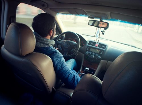 Man Wearing Blue Jacket Sitting Inside Car While Driving
