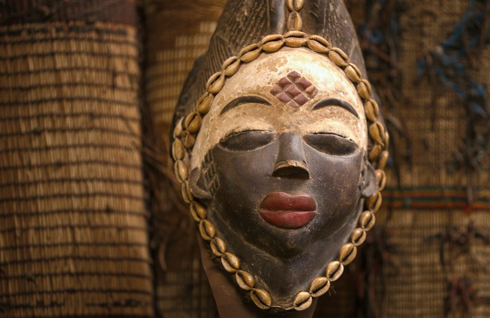 gold and black mask on brown brick wall