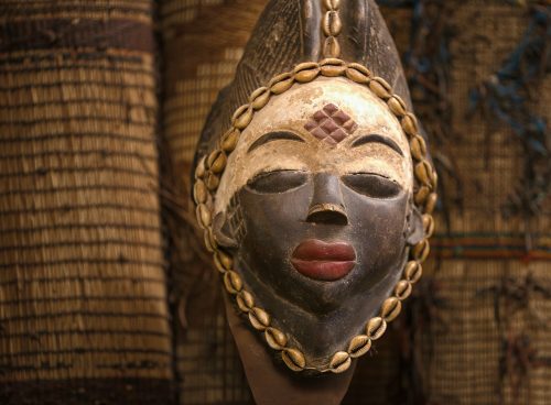 gold and black mask on brown brick wall