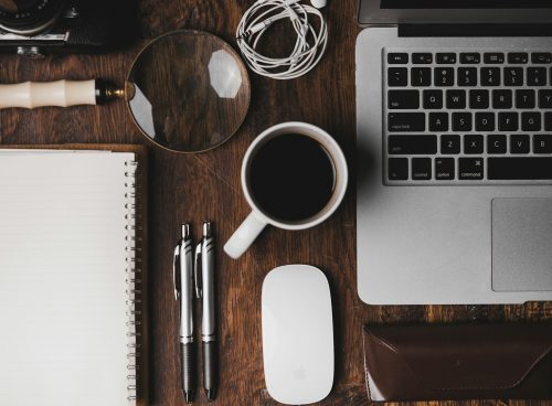 cup of coffee near MacBook Pro