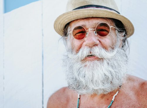 a man with a white beard and mustache wearing a hat