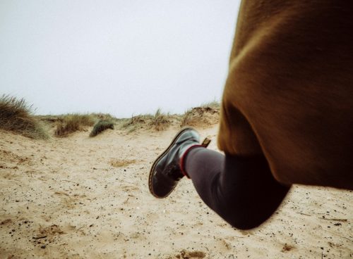 person walking on sandy ground