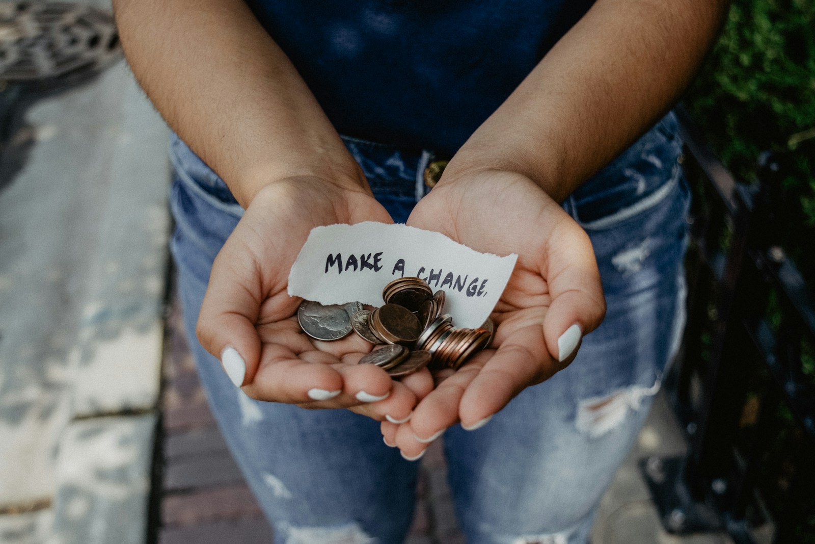 What Are the Ways to Incorporate Charitable Giving into Your Wedding? 1 person showing both hands with make a change note and coins