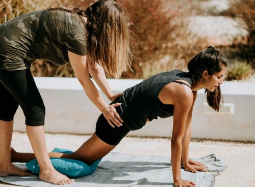 woman in black tank top and black shorts kneeling on mat