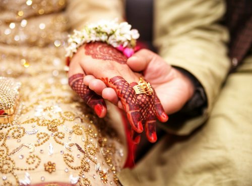 person holding hands wearing gold-colored ring