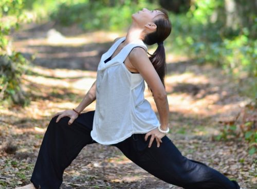 a woman is doing yoga in the woods