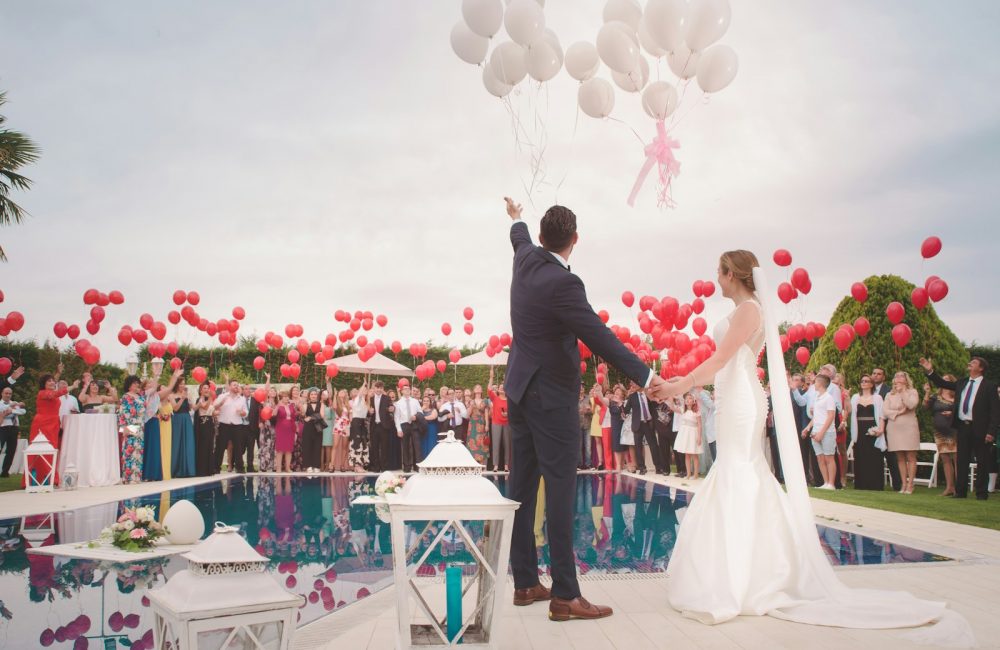 photo of a man and woman newly wedding holding a balloons