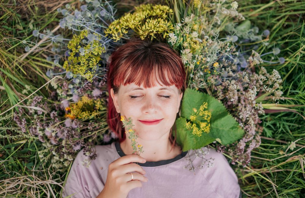 woman in gray crew neck shirt lying on green grass