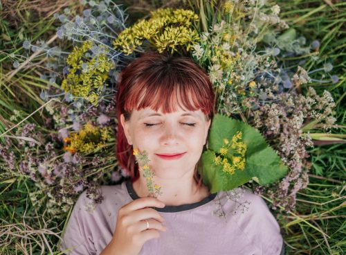 woman in gray crew neck shirt lying on green grass
