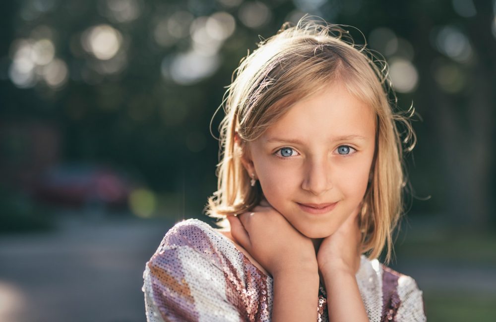 selective focus photography of girl in sequined white-and-pink stripe shirt