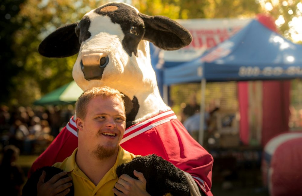 men near cow mascot