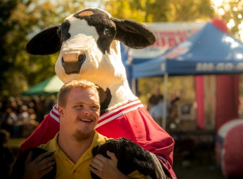 men near cow mascot