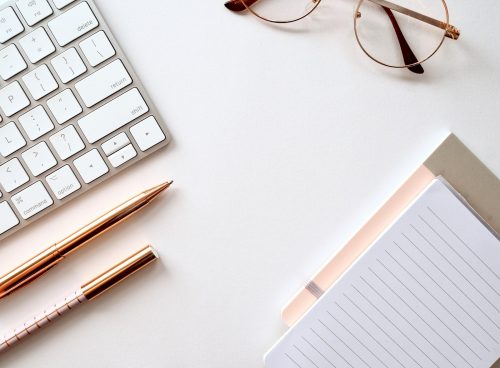 pen near black lined paper and eyeglasses