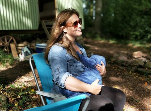 woman carrying baby while sitting on chair