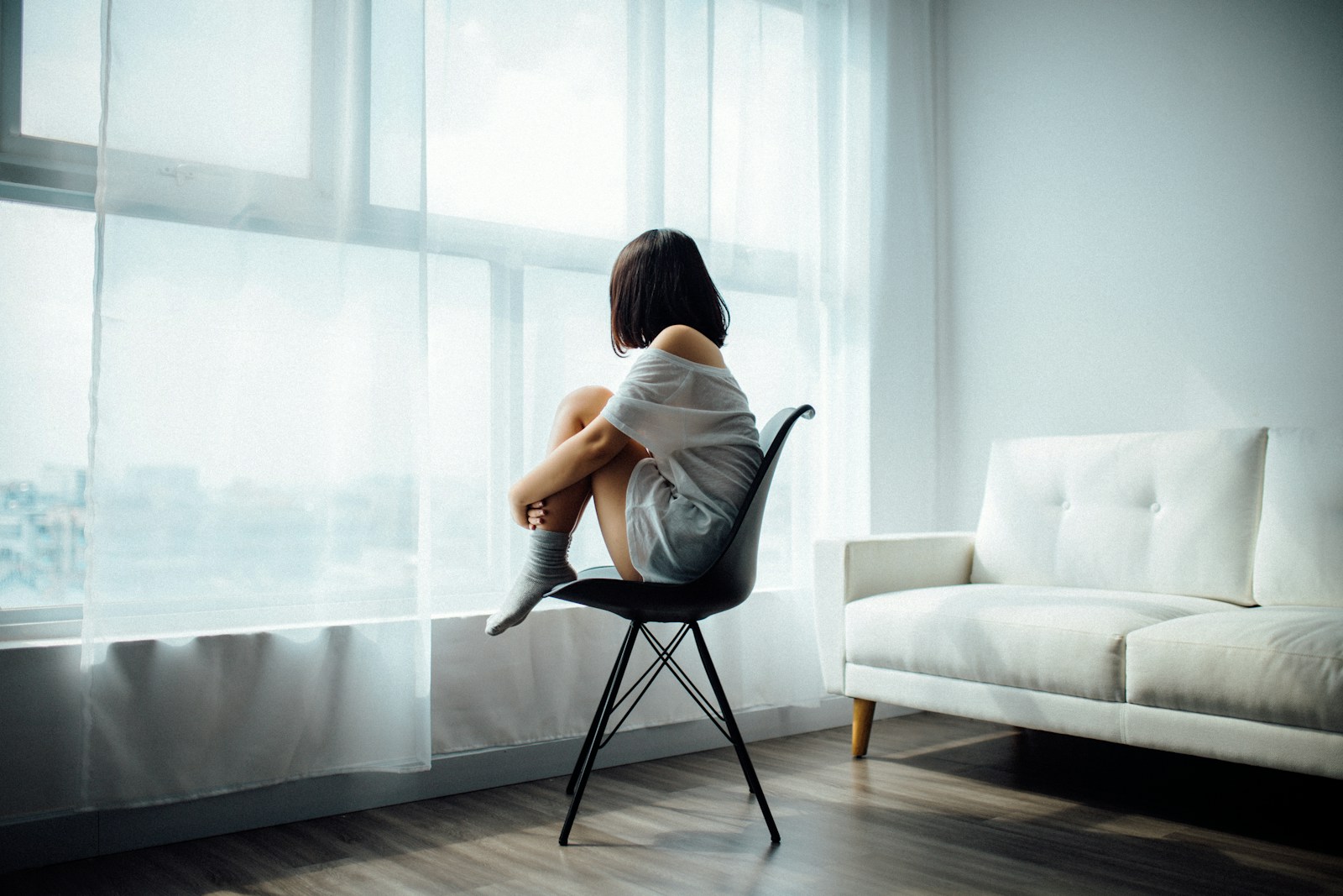Characteristics of effective depression treatment 1 woman sitting on black chair in front of glass-panel window with white curtains