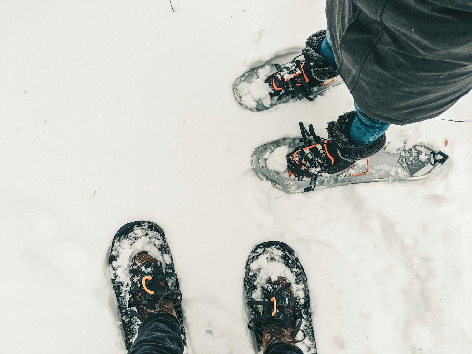 20 Benefits of Regular Snowshoeing for Winter Fitness and Exploration 1 person in black pants and black and white snow ski shoes standing on snow covered ground