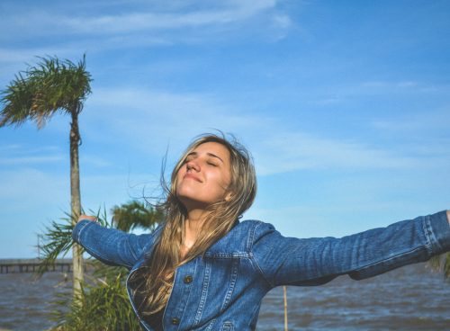woman spreading arms near body of water