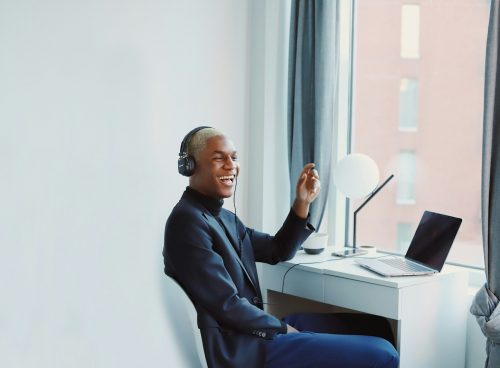 man in black long sleeve shirt sitting on blue chair