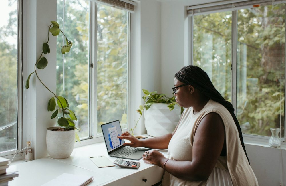 a woman sitting at a table with a laptop