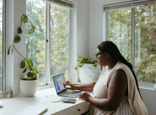 a woman sitting at a table with a laptop
