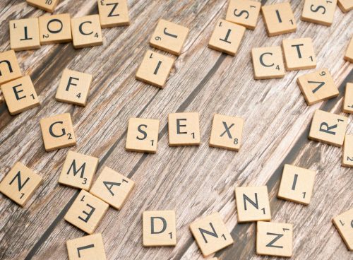 Scrabble letters spelling out sex on a wooden table