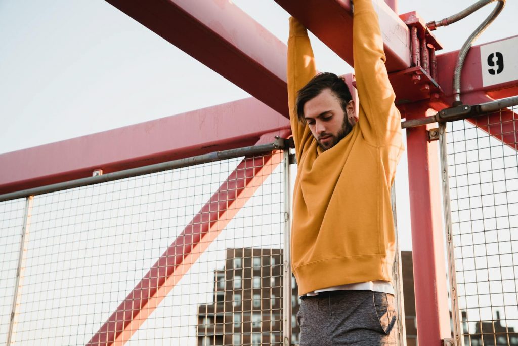 15 Sports and Exercises that Promote Height Growth in Teenagers 10 Strong man hanging on metal construction