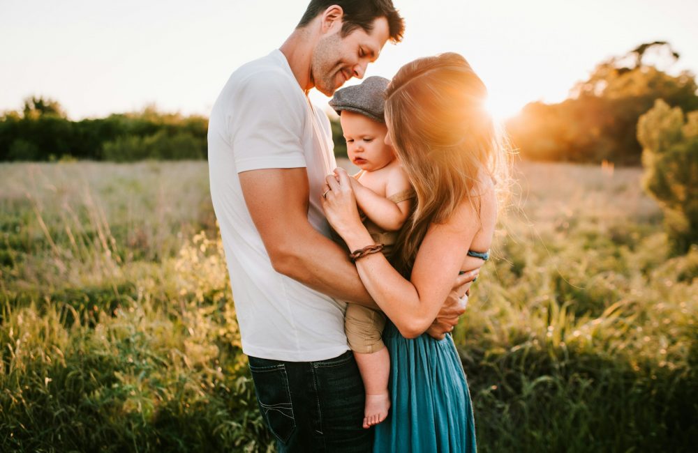 family photo on green grass during golden hour