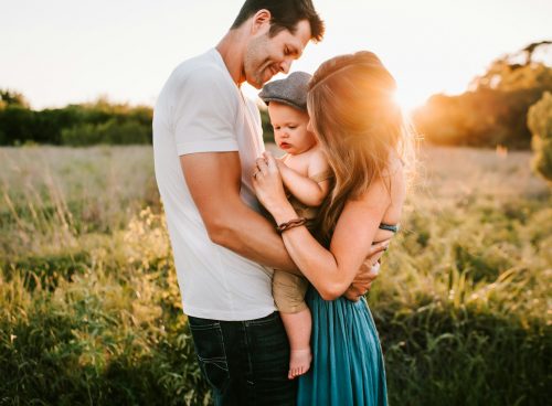 family photo on green grass during golden hour