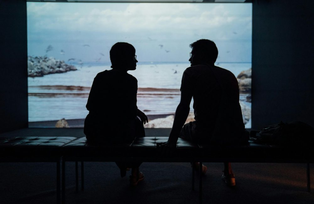 silhouette of man and woman sitting on ottoman