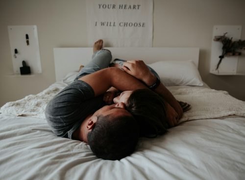 A man and woman cuddling together in bed.
