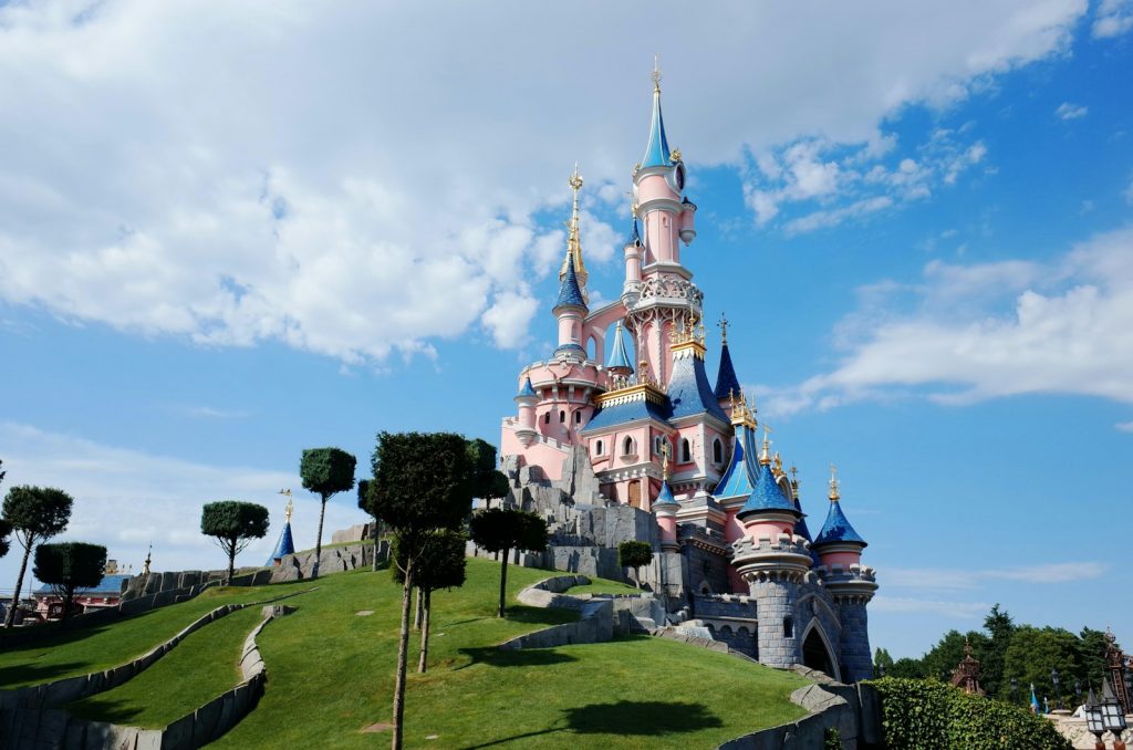 14 Best Places to Visit for Theme Parks 8 white and blue castle under white clouds and blue sky during daytime