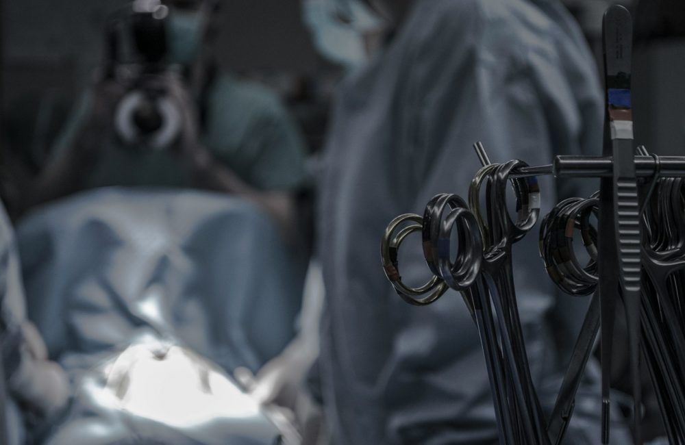 gray surgical scissors near doctors in operating room