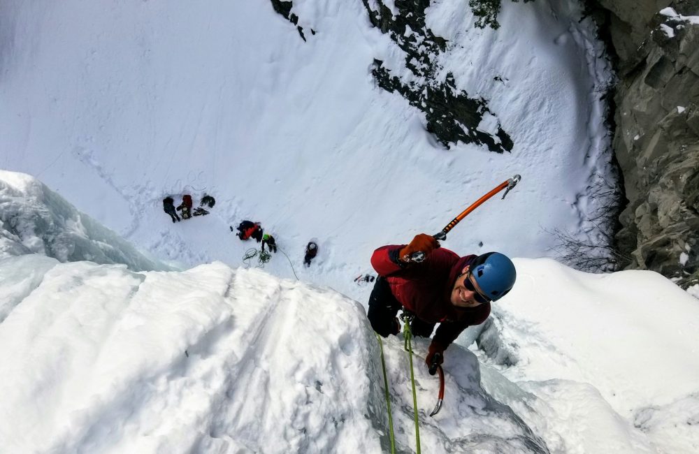 man wearing long-sleeved shirt climbing on mountain