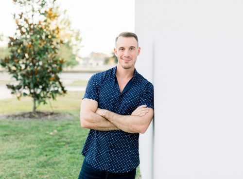 a man leaning against a wall with his arms crossed