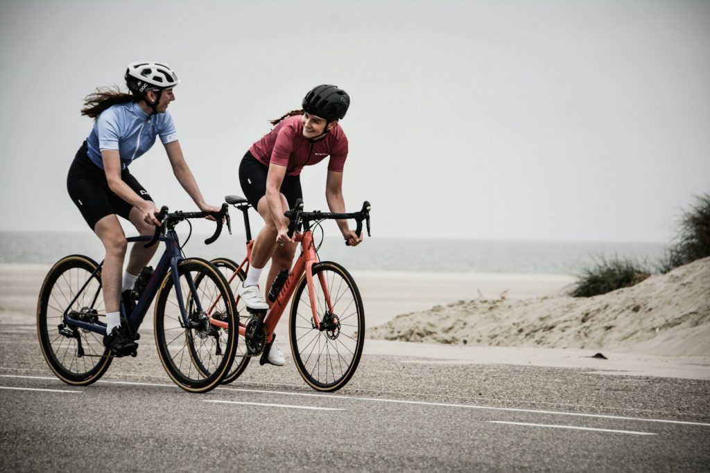 15 Sports and Exercises that Promote Height Growth in Teenagers 13 man and woman riding road bikes at the road near shore