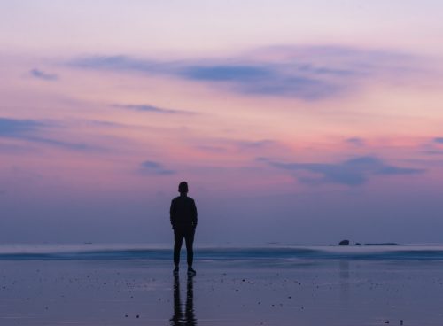 silhouette of man standing on seashore