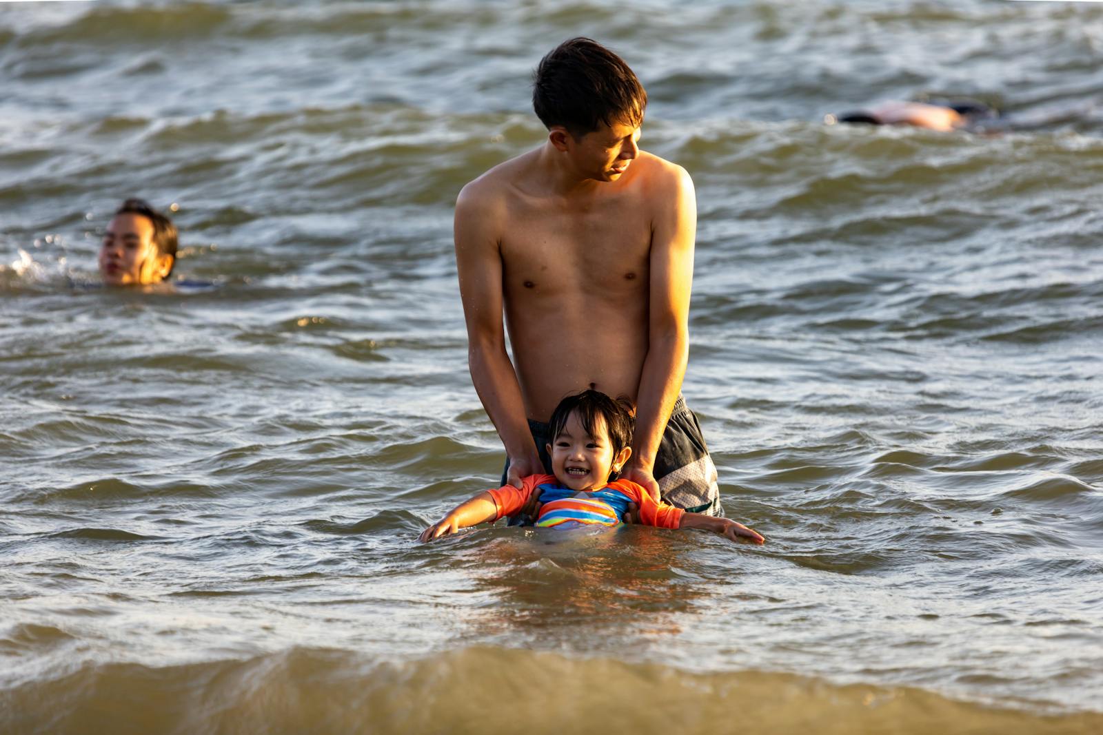 Father Holding his Son While on Shallow Water