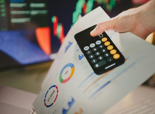 a person holding a calculator over a piece of paper