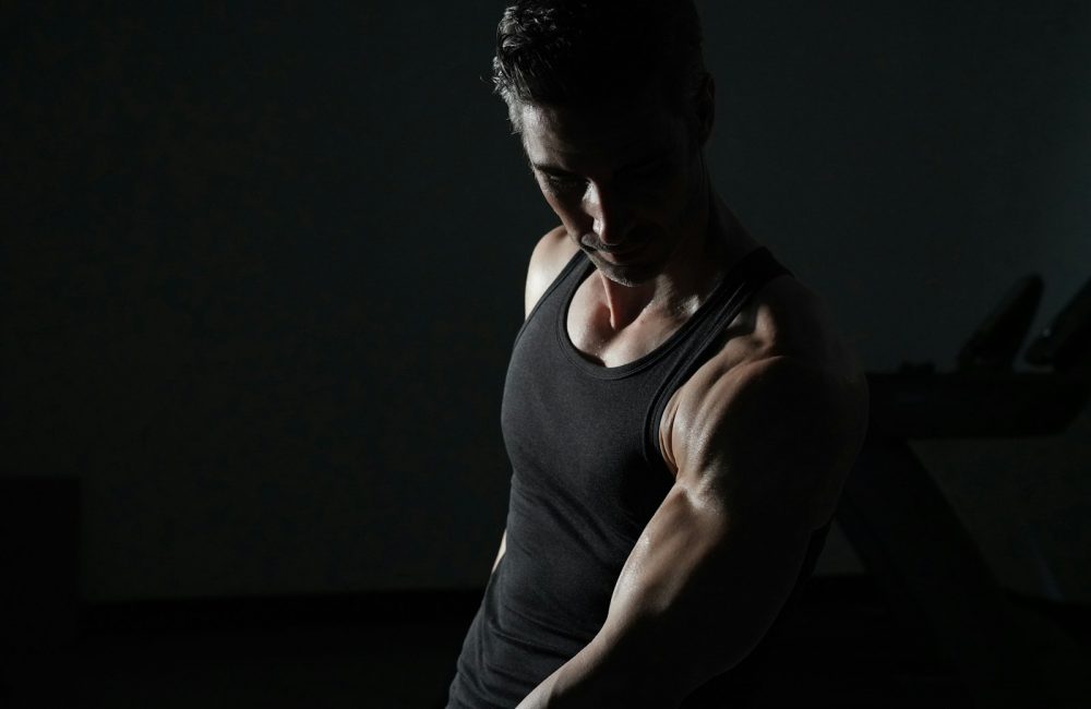 a man in a black tank top is doing exercises