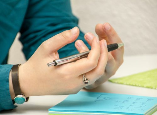 a person sitting at a table using a cell phone