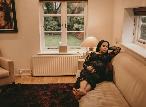 woman sitting on brown sofa near white radiator panel under glass window