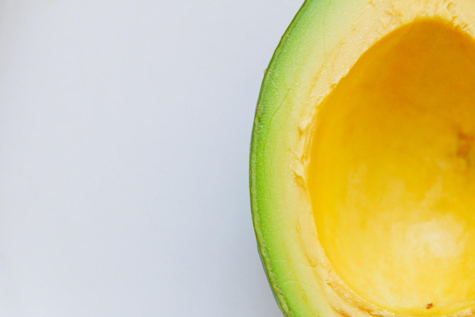 Is Avocado Oil Healthier Than Olive Oil for Cooking? 1 sliced avocado against white background