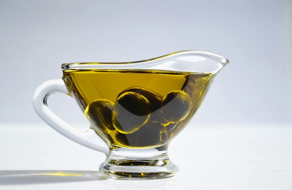 Photo of Olives on Cup of Olive Oil