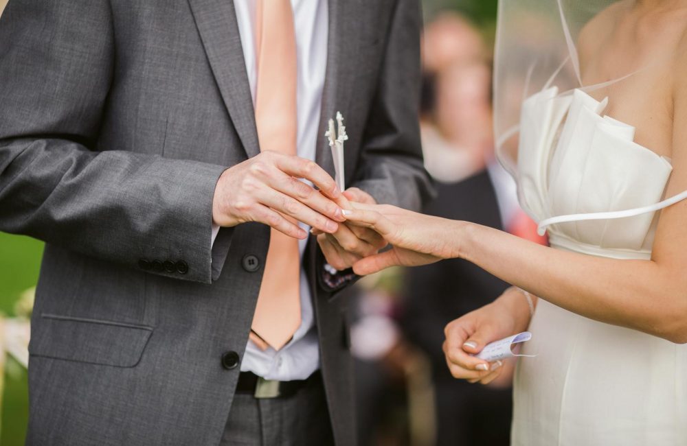 Photo of Groom Putting Wedding Ring on His Bride