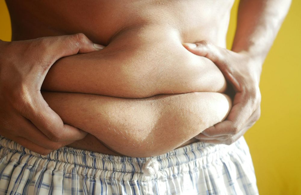 A Person Holding on to Belly Fat