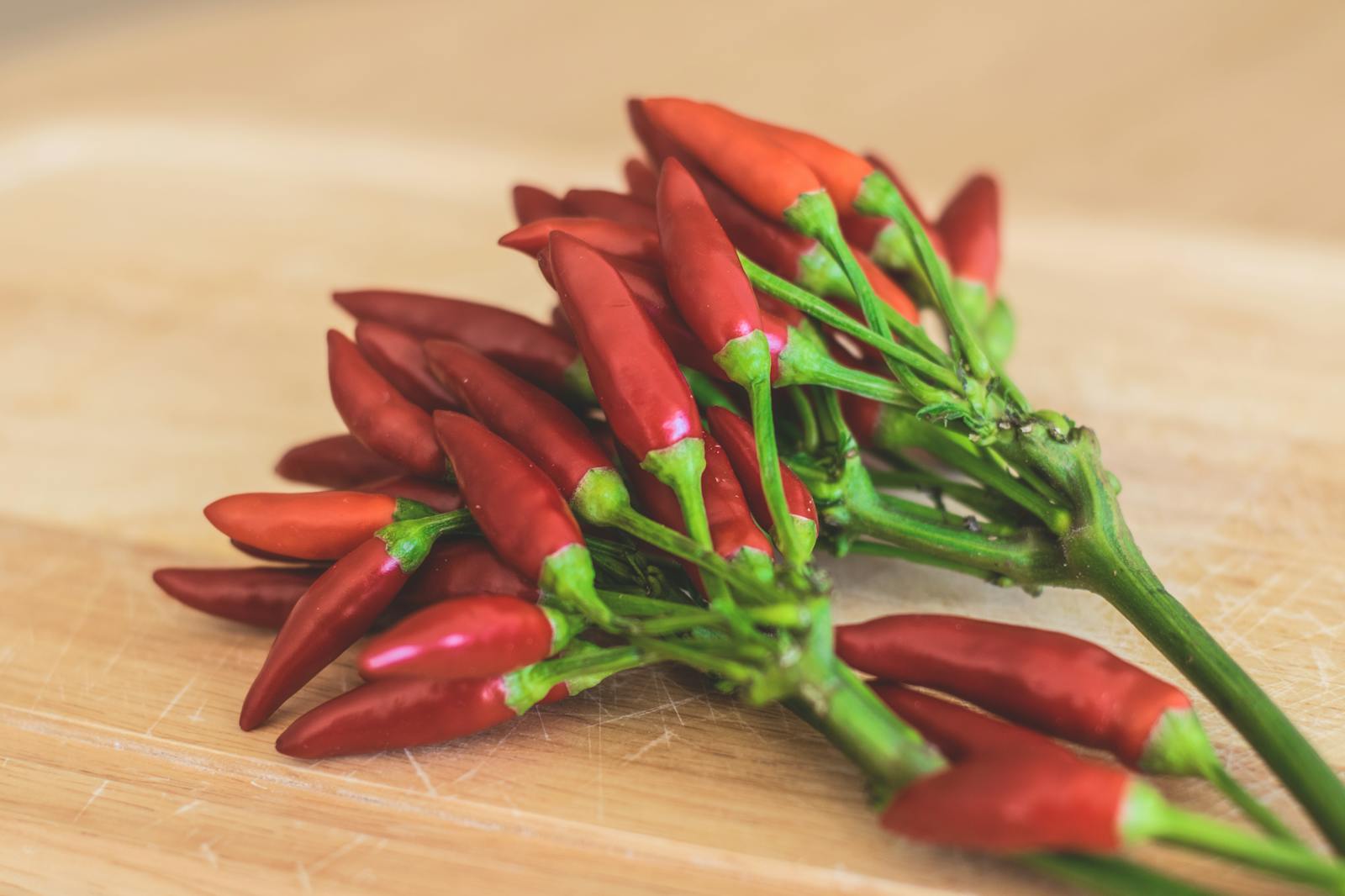 12 Best Foods High in Capsaicin for Metabolism Boosting 1 Red Chili Peppers on Brown Wooden Surface