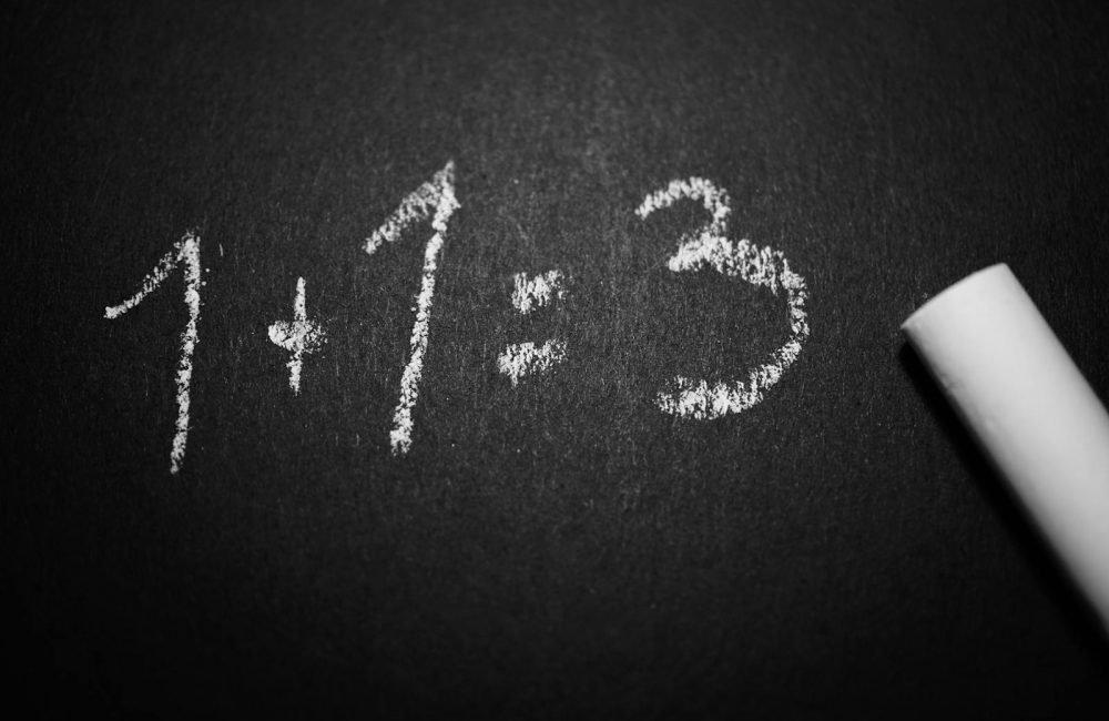 1 + 1 = 3 Text on Black Chalkboard