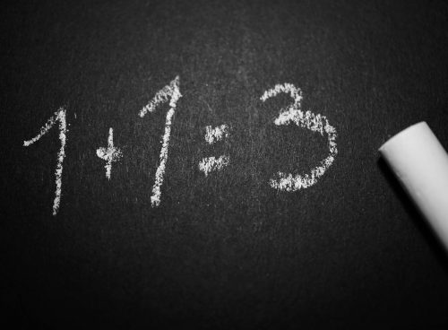 1 + 1 = 3 Text on Black Chalkboard